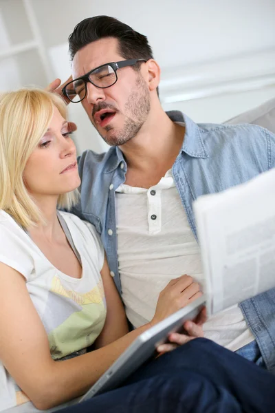 Pareja leyendo noticias con mirada horrorizada — Foto de Stock