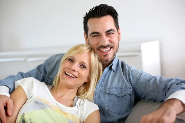 Söt medelålders par omfattar i soffa — Stockfoto