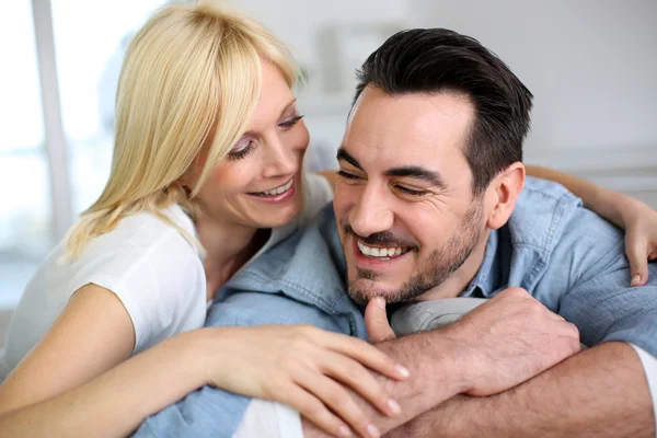 Doce casal de meia-idade abraçando no sofá — Fotografia de Stock