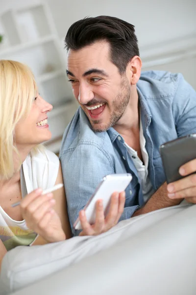 Casal alegre se divertindo usando smartphone — Fotografia de Stock