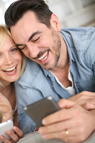 Vrolijke paar plezier gebruikend smartphone — Stockfoto