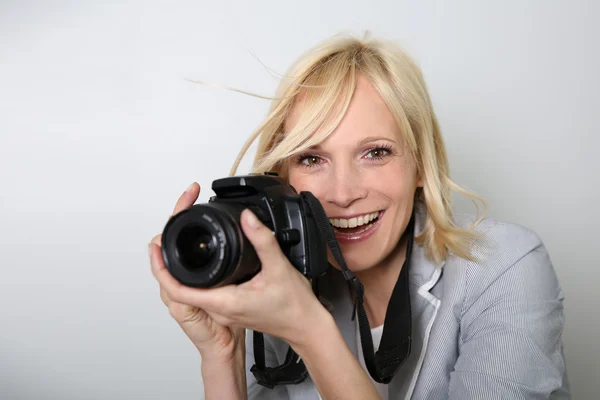 Mulher alegre fotógrafo segurando câmera — Fotografia de Stock
