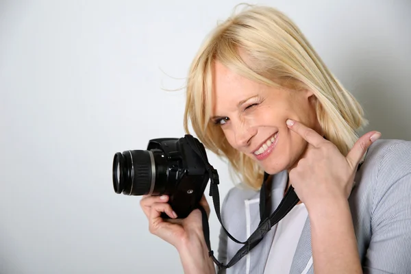 Mulher alegre fotógrafo segurando câmera — Fotografia de Stock