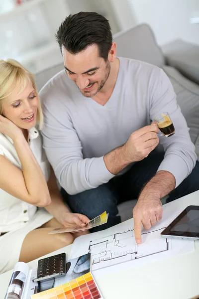 Paar kijken naar verfkleuren voor nieuw huis — Stockfoto