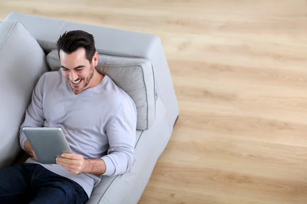 Верхний вид человека с помощью планшетного дивана — стоковое фото