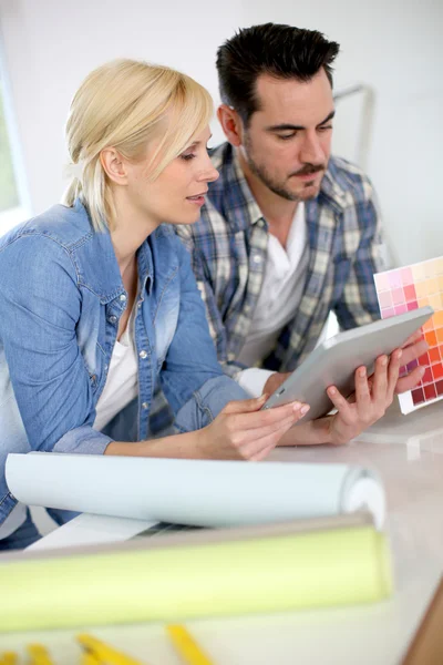 Pareja de mediana edad eligiendo colores de pared para un nuevo hogar — Foto de Stock