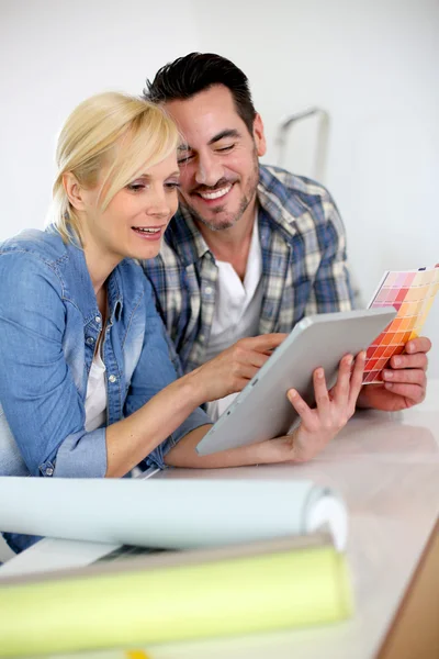 Middle-aged couple choosing wall colours for new home — Stock Photo, Image