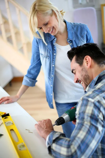 Par installera möbler i nya huset — Stockfoto