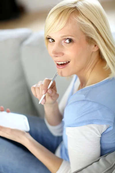 Chica alegre usando teléfono inteligente sentado en el sofá — Foto de Stock