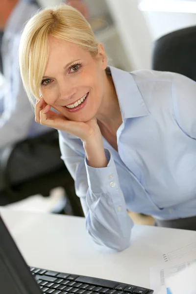 Mulher de negócios alegre sentado na frente do desktop — Fotografia de Stock
