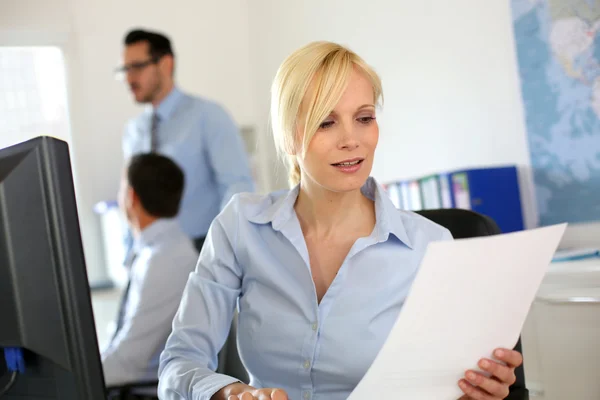 Femme d'affaires lisant un document au travail — Photo