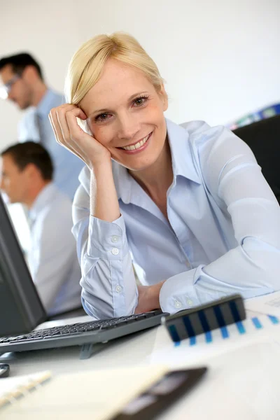 デスクトップの前に座っている陽気な女性実業家 — ストック写真