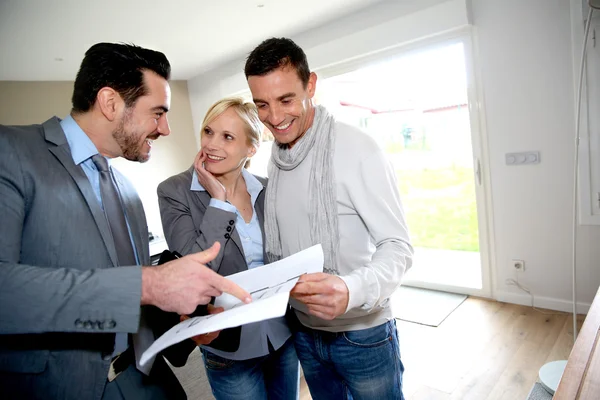 Medelålders par besöker huset med säljare — Stockfoto