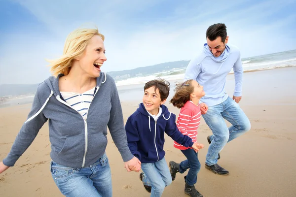 Família correndo na praia — Fotografia de Stock