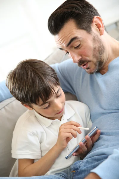 Menino com o pai brincando com smartphone — Fotografia de Stock