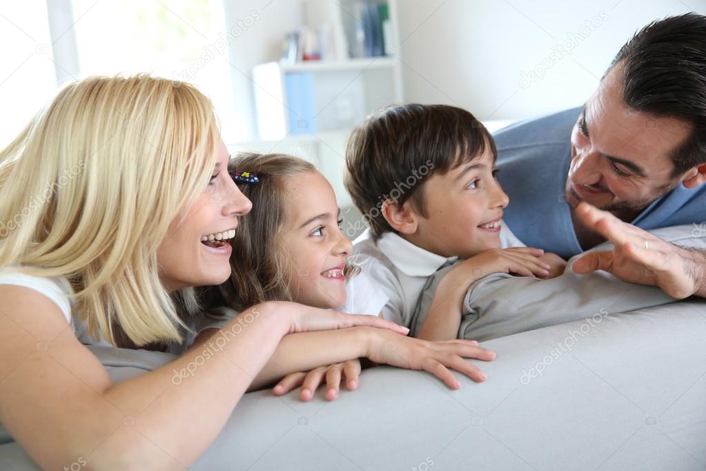 Family of four sitting in sofa at home