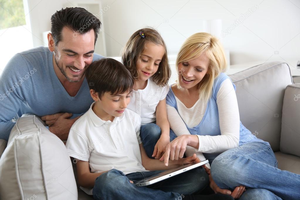 Family relaxing with kids and using digital tablet