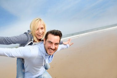 eğlenceli bir kumsala sahip orta yaşlı çift