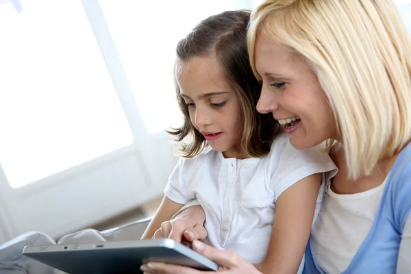 Madre e hija jugando con la tableta electrónica — Foto de Stock