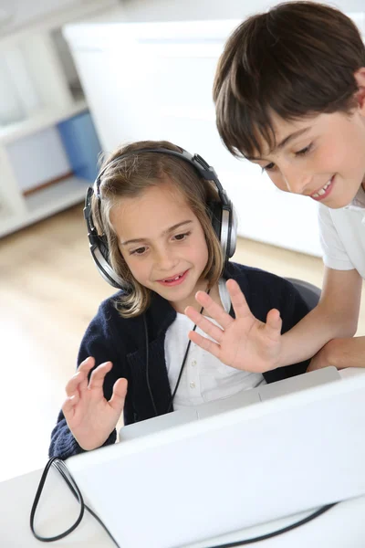 Portrait of kids waving at webcamera with laptop — Stock Photo, Image