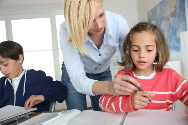 Kinder sitzen mit Lehrer im Klassenzimmer — Stockfoto