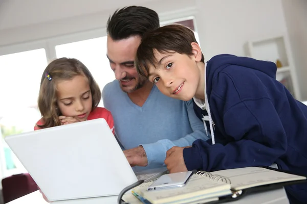 Uomo con bambini che utilizzano il computer portatile a casa — Foto Stock