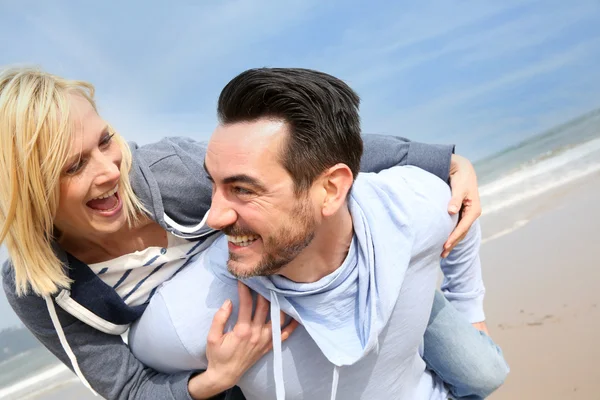 Middle-aged couple having fun on a sandy beach — Stock Photo, Image