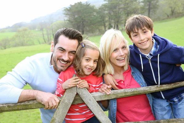 Familia apoyada en una valla en el campo — Foto de Stock