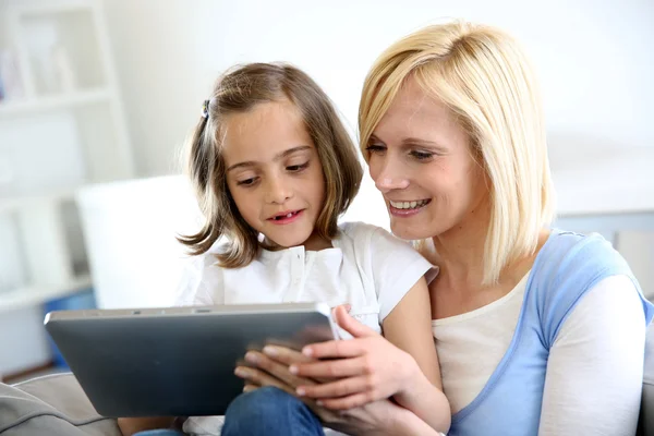 Madre e hija jugando con la tableta electrónica Fotos de stock libres de derechos