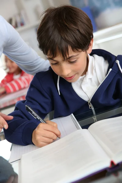 Young schoolboy sitting in classroom — Stock Photo, Image