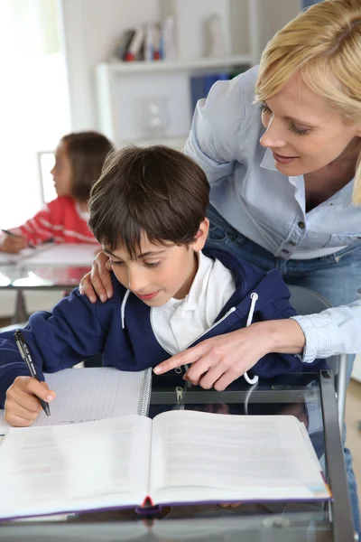 Učitelka pomáhá mladý chlapec s lekce Stock Snímky
