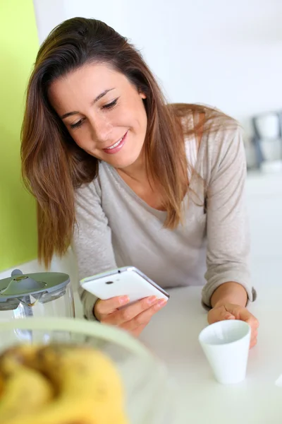 Jeune femme à la maison envoyer un message avec smartphone — Photo