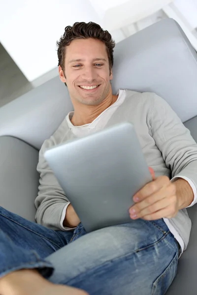 Homem adulto deitado no sofá com tablet — Fotografia de Stock