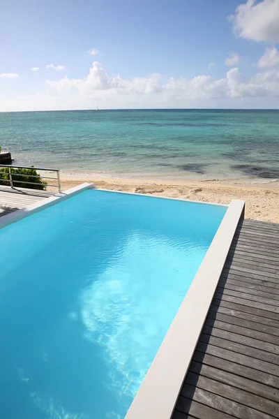 Bela vista da piscina infinita com deck de madeira — Fotografia de Stock