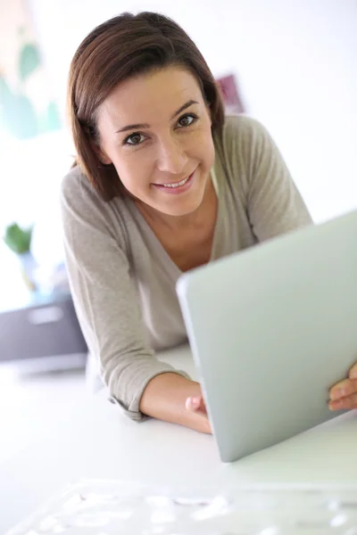 Jovem mulher alegre usando tablet eletrônico — Fotografia de Stock