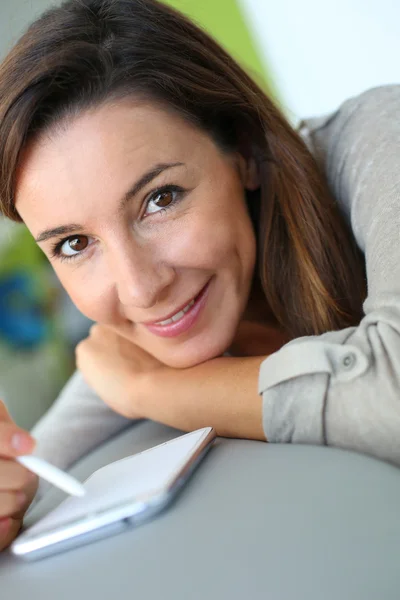 Junge Frau nutzt Smartphone zu Hause — Stockfoto