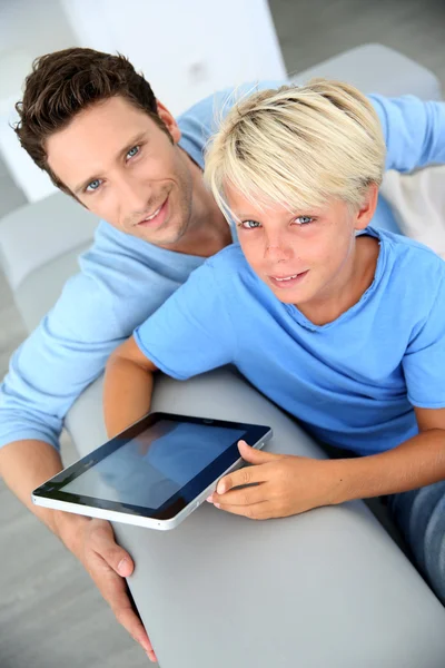 Pai e filho usando tablet digital em casa — Fotografia de Stock