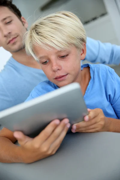 Vader en zoon die thuis digitale tablet gebruiken — Stockfoto