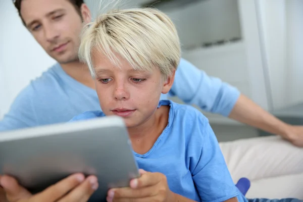 Ojciec i syn korzystający z tabletu cyfrowego w domu — Zdjęcie stockowe