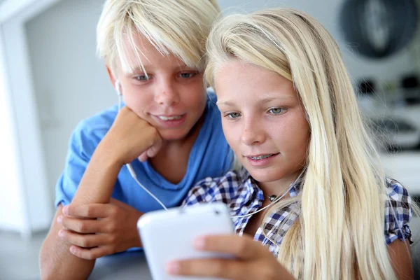 Adolescentes usando smartphone com fones de ouvido — Fotografia de Stock
