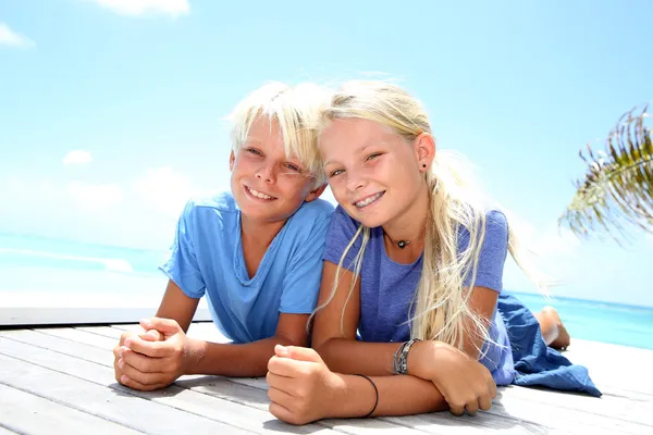 Blonde tieners opleggen zwembad dek in de zomer — Stockfoto