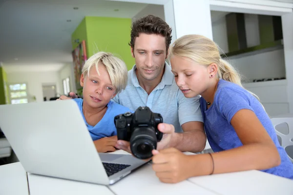 Muž s teenagery, při pohledu na obrázky na počítači — Stock fotografie