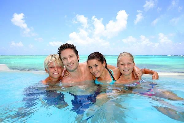 Familia de cuatro personas bañándose en la piscina — Foto de Stock