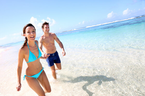 Pareja corriendo en una playa de arena — Foto de Stock