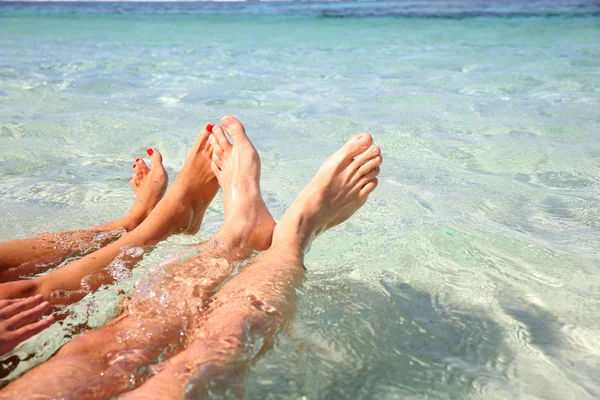 Närbild av parets fötter i lagunen vatten — Stockfoto