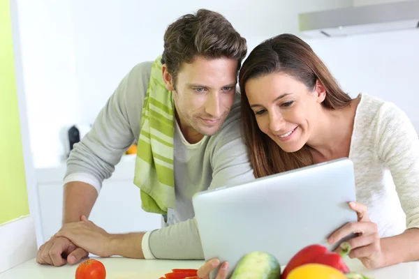 Paar in huis keuken op zoek naar lunch recept — Stockfoto
