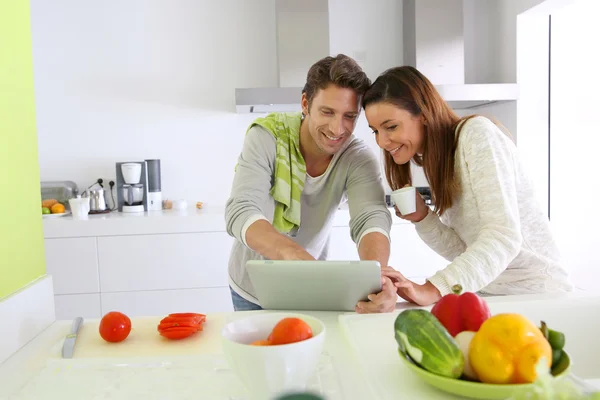 Couple dans la cuisine à la maison à la recherche d'une recette de déjeuner — Photo