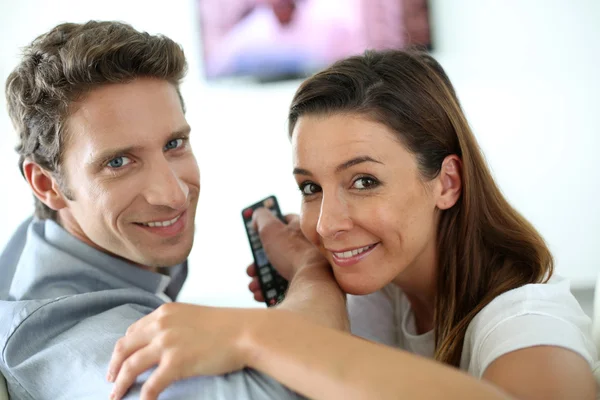 Couple souriant regarder un film sur la télévision — Photo