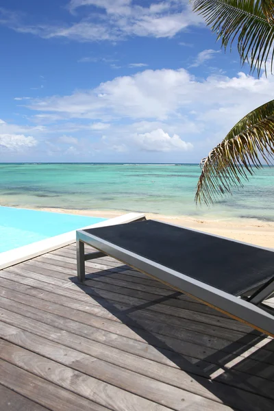 Piscina infinita con tumbona junto a la playa —  Fotos de Stock