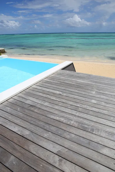 Belle vue sur piscine à débordement avec terrasse en bois — Photo